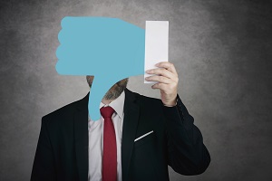 Businessman holding a dislike icon on gray background